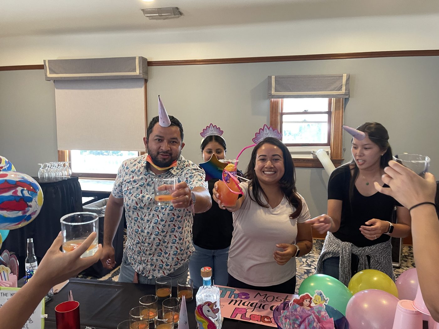 A team raising its creations behind a colorful display